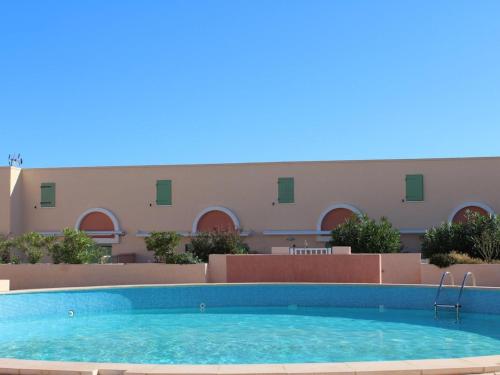 une piscine devant un immeuble dans l'établissement Maison 4 pièces avec piscine, parking, et lave-vaisselle à Gruissan - FR-1-229-112, à Gruissan
