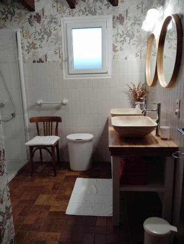 une salle de bain avec un lavabo et des toilettes et une fenêtre dans l'établissement La petite bretonne de Tréompan, à Ploudalmézeau