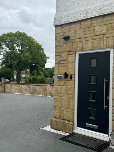 a black door on the side of a brick building at Westminster Guest House in Oxford