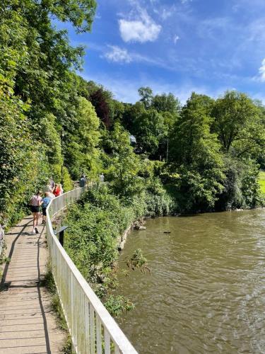 a group of people walking on a bridge over a river at Chalet 139 Hakuna Matata in Durbuy