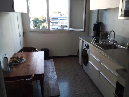 une cuisine avec une table et une machine à laver dans l'établissement T3 proche calanque et stade velodrome lumineux et confortable, à Marseille