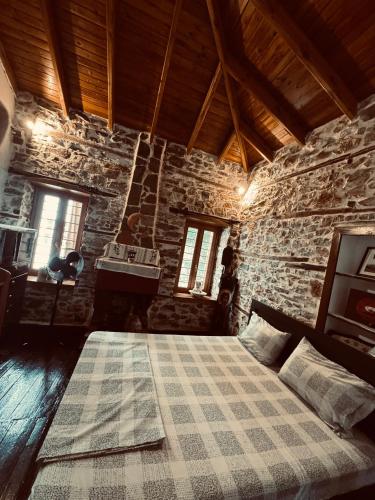 a bedroom with a bed in a stone building at Villa Tzeni Palios Panteleimon in Panteleímon
