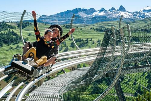 two people riding on a zip line in the mountains at Grande Maison au pied du Col in Arvieux