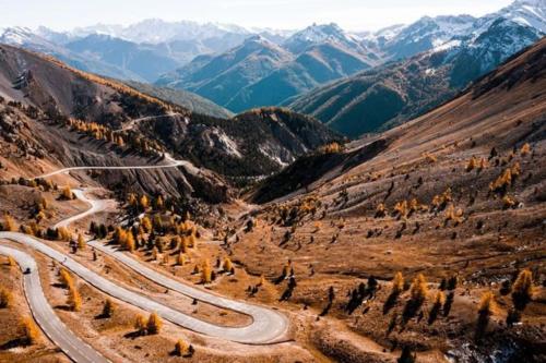 a winding road in a valley with mountains at Grande Maison au pied du Col in Arvieux