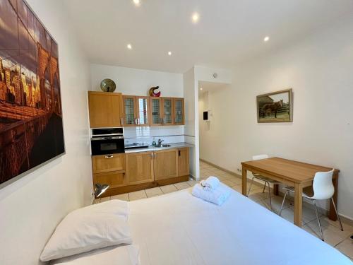 une chambre avec un lit et un bureau et une cuisine dans l'établissement Viva Riviera Residence Rue Florian close Croisette, à Cannes