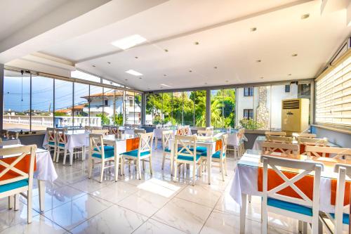 a restaurant with tables and chairs and windows at LESLION HOTEL TURUNC in Marmaris