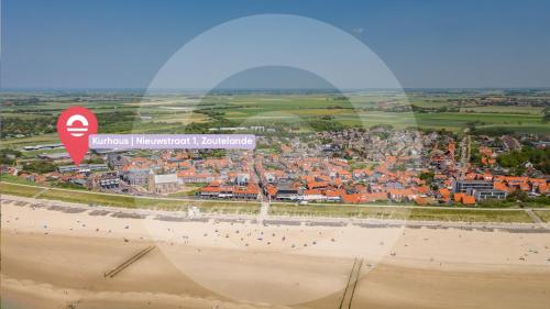 a view of a beach with people on the beach at Welcome in - Appartementen Kurhaus - Nieuwstraat 1 Zoutelande, nabij strand, terras, sauna in Zoutelande