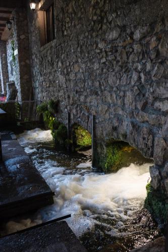 a stream in front of a stone building at Adria centar Koćuša in Ljubuški