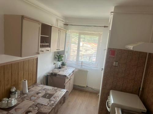 a small kitchen with a table and a window at Apartament La Ilie in Ocna Sibiului
