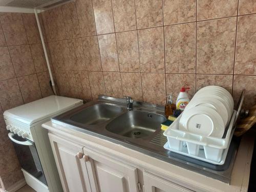 a kitchen counter with a sink and a refrigerator at Apartament La Ilie in Ocna Sibiului