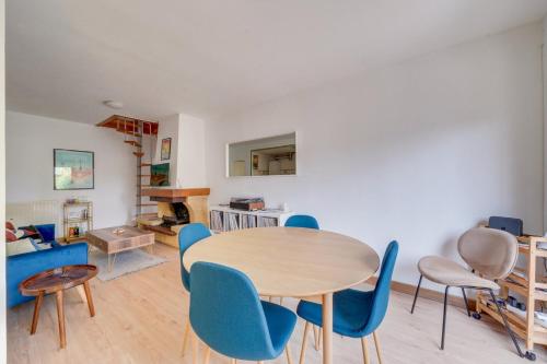 une salle à manger avec une table et des chaises bleues dans l'établissement Maison de charme à Bacalan avec Terrasse, à Bordeaux