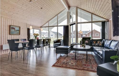 Una sala de estar con un sofá, una mesa y sillas. en Four-Bedroom Holiday Home With A Fireplace In Bogense, en Bogense