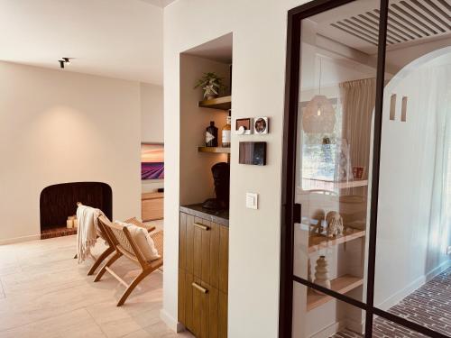 a room with a glass door and a chair in a room at Maison Marelle in Koksijde