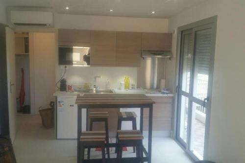 - une cuisine avec une table et quelques tabourets dans l'établissement STUDIO VUE MER 28m2 200M DE LA PLAGE, à Nice
