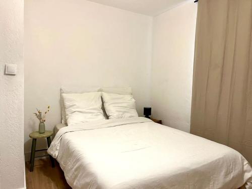 - un lit blanc dans une chambre blanche avec une table dans l'établissement La Lumineuse - 5 min du Vieux Port Rue Piétonne - Les Frères de la Loc', à Marseille