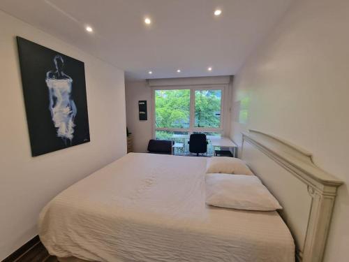 une chambre avec un grand lit et une fenêtre dans l'établissement Appartement Chic près du Stade de France, à Saint-Ouen