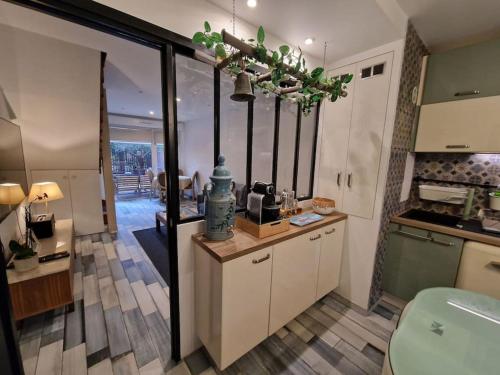 une cuisine avec des placards blancs et une grande fenêtre dans l'établissement Appartement Chic près du Stade de France, à Saint-Ouen