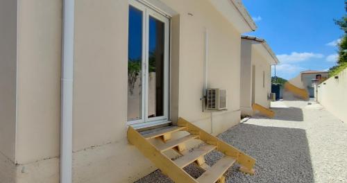 a bench next to a building with a window at Les Pins du Lac II in Lacoste