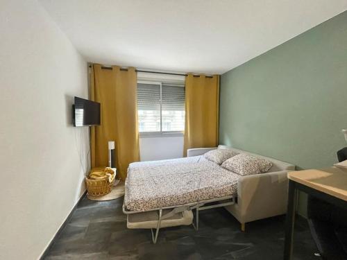 une chambre avec un lit et une fenêtre dans l'établissement Carré Or Marseille Paradis, à Marseille