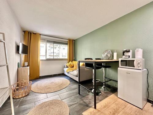 - un salon avec une table et un four micro-ondes dans l'établissement Carré Or Marseille Paradis, à Marseille