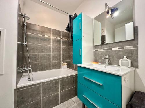 La salle de bains est pourvue d'une armoire bleue et d'une baignoire. dans l'établissement Carré Or Marseille Paradis, à Marseille