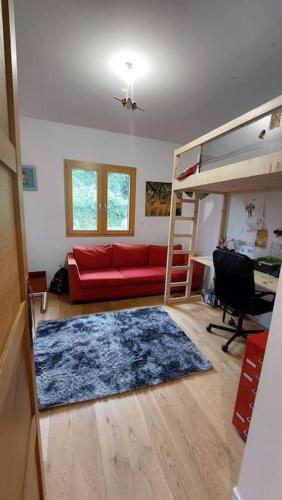 un salon avec un canapé rouge et un lit superposé dans l'établissement Maison et piscine bien située en sud ardeche très grand jardin, à Saint-Paul-le-Jeune