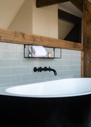 a white bath tub in a bathroom with a sink at B&B Hartenlust kamer de Hooizolder in Bodegraven