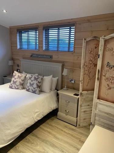 a bedroom with a bed and two windows at The Shore in Eyemouth
