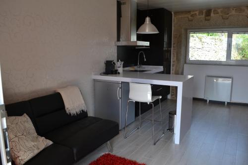 eine Küche mit einem Sofa und einer Theke in einem Zimmer in der Unterkunft Casa de Moreira in Calo