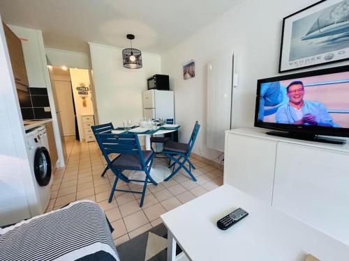 un salon avec une télévision et une salle à manger dans l'établissement 