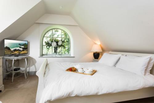 a bedroom with a bed with a tray of fruit on it at Coach House Kent in Seal