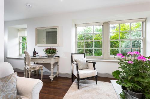 a living room with a desk and chairs and windows at Coach House Kent in Seal