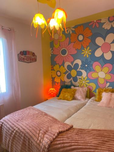 - 2 lits dans une chambre ornée de fleurs sur le mur dans l'établissement Inspiration maison entière avec jardin, à Pernes-les-Fontaines