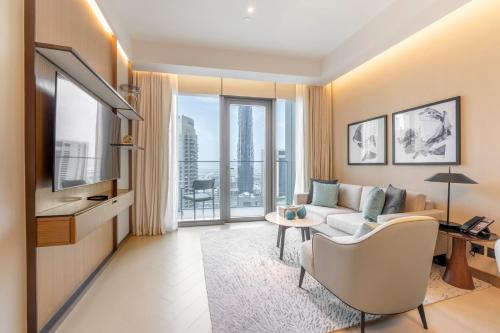 a living room with a couch and a tv at Address Opera Residences Burj Khalifa View in Dubai