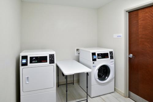 a laundry room with a washer and dryer at Holiday Inn Express Hotel & Suites Carthage by IHG in Carthage