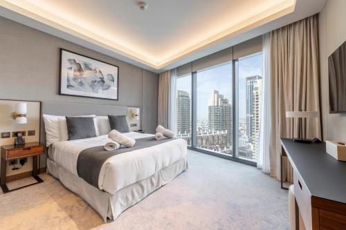 a bedroom with a large bed and a large window at Address Opera Residences Burj Khalifa View in Dubai