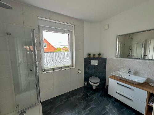 KarstädtにあるFerienhaus Wegblüteの洗面台、トイレ、窓のあるバスルーム