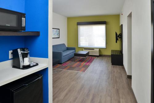 a living room with a couch and a living room with a tv at Holiday Inn Express Hotel & Suites Carthage by IHG in Carthage