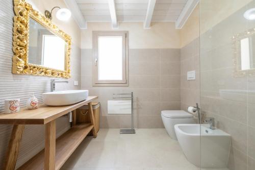 a bathroom with a sink and a toilet and a mirror at Villachiadream in Chia