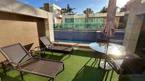 a patio with chairs and a table and a pool at Jade Hotel Brasília in Brasilia