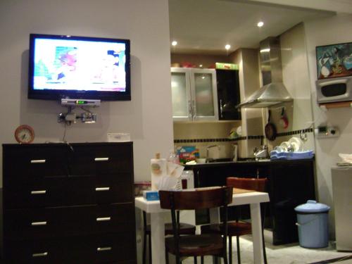 a kitchen with a tv on the wall and a kitchen at Studio Résidence Neptune Sousse Zone Kantaoui in Port El Kantaoui