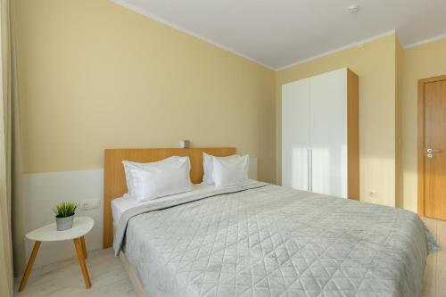 a bedroom with a large bed and a table at St. Panteleimon Beach Hotel in Nesebar