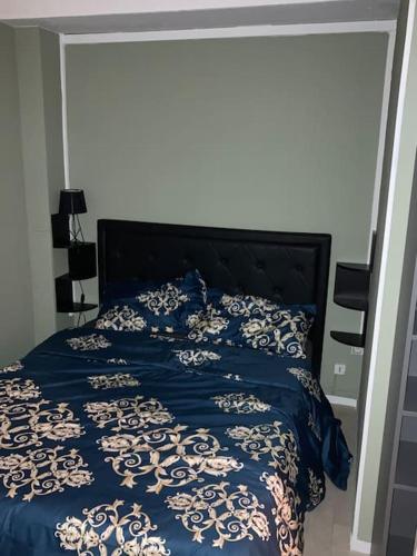 une chambre avec un lit avec une couette bleue et blanche dans l'établissement Rooftop Appartement 75017, à Paris