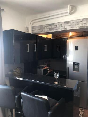 une cuisine avec un bar avec un verre à vin dessus dans l'établissement Rooftop Appartement 75017, à Paris