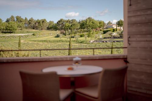 a window with a table and a view of a field at Coquillade Provence - Relais & Châteaux in Gargas