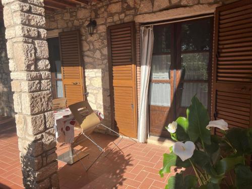 a patio with a chair and some wooden doors at Agriturismo La Castellina in Saturnia