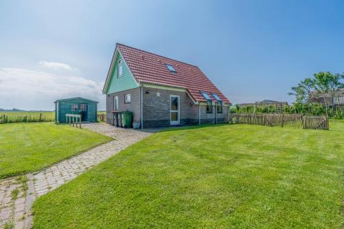 a house with a green roof and a yard at Postweg 50 in De Cocksdorp