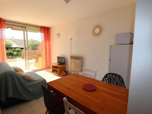 un salon avec une table et un réfrigérateur dans l'établissement Appartement 2P avec cabine, grande terrasse, parking, 400m plage - FR-1-307-129, au Grau-du-Roi