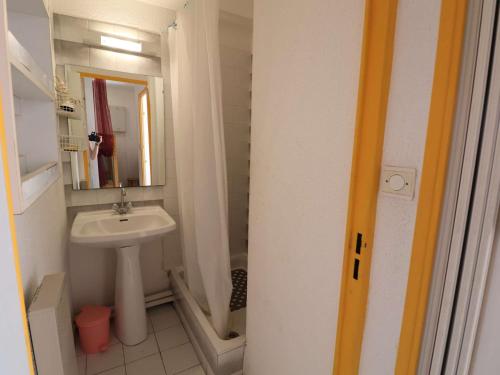 une petite salle de bain avec un lavabo et un miroir dans l'établissement Appartement 2P avec cabine, grande terrasse, parking, 400m plage - FR-1-307-129, au Grau-du-Roi