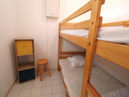 Cette petite chambre comprend 2 lits superposés et un tabouret. dans l'établissement Appartement 2P avec cabine, grande terrasse, parking, 400m plage - FR-1-307-129, au Grau-du-Roi